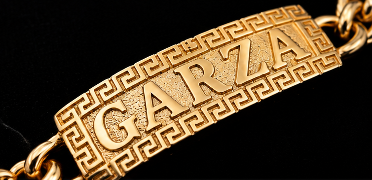Close-up of a custom GARZA gold nameplate with Greek-key frame