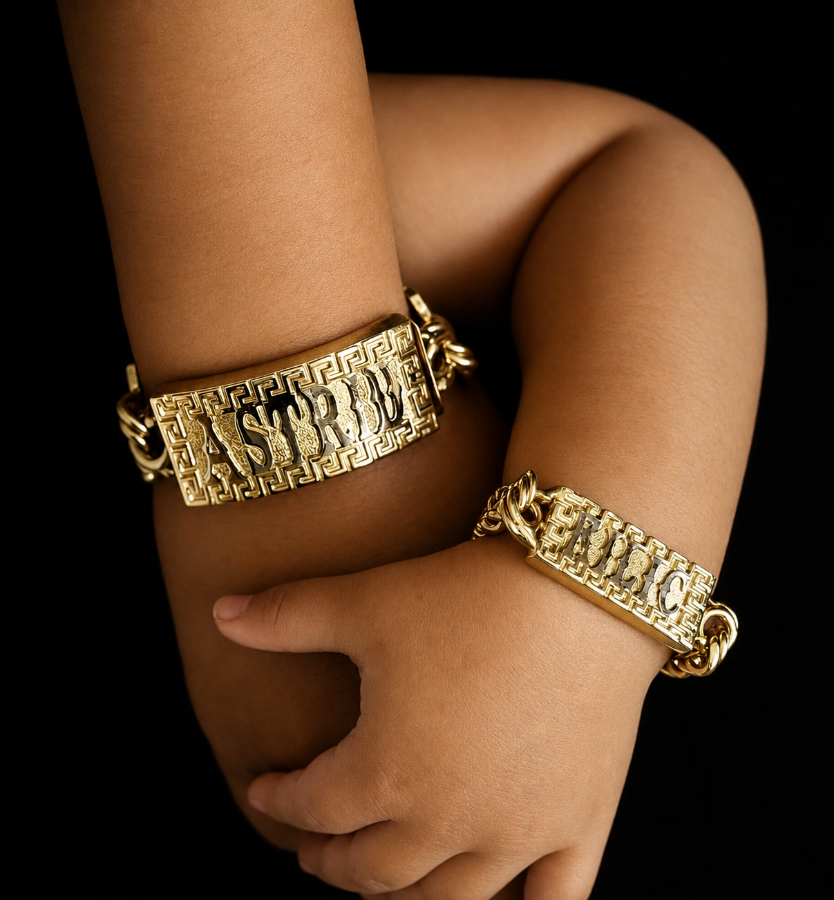 Two gold Jonny Jewels esclavas with Greek-key frames worn on wrists